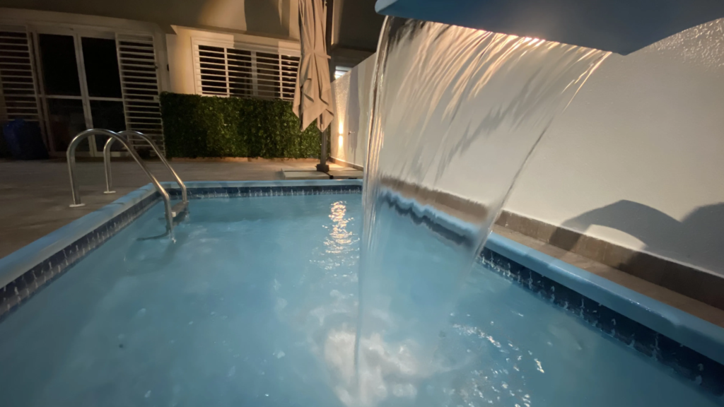 Private illuminated swimming pool at night at the NYC Park Ave Residence in Ponta Negra, Brazil